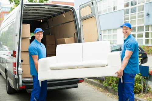 Man with van loading furniture in Docklands near modern apartment buildings