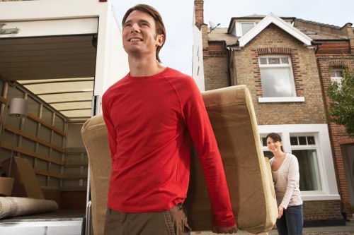 Professional movers handling household furniture in a Docklands residential building