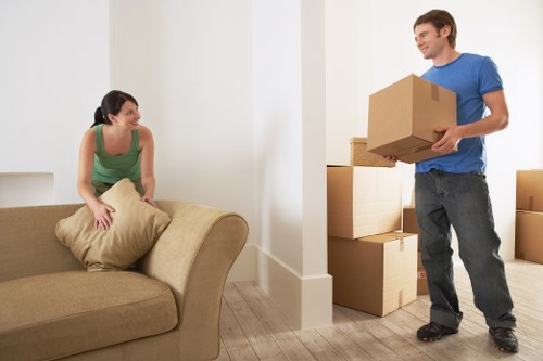 Removal workers carrying boxes through a Docklands apartment corridor